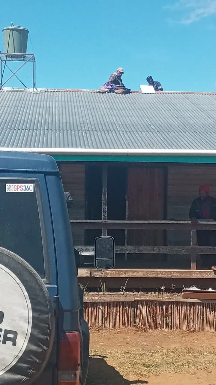 GPS360 crew mounting a Starlink dish on a corrugated iron roof